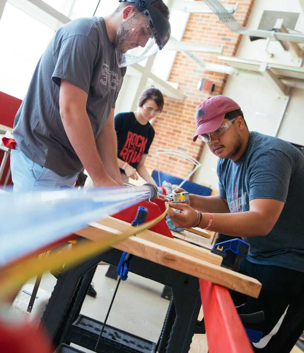 Students collaborating on a hands-on engineering project in a workshop.